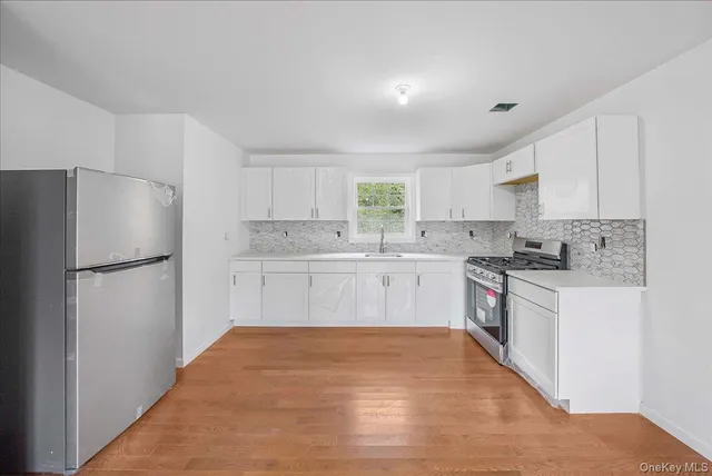 a kitchen with a refrigerator a sink and cabinets