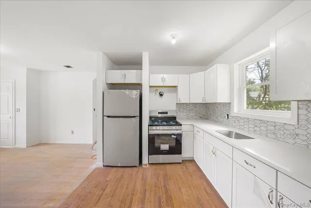 a kitchen with a sink cabinets stainless steel appliances and a window