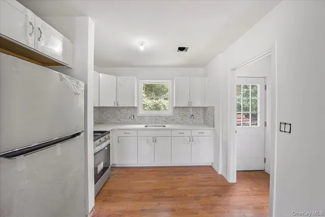 a kitchen with a sink cabinets stainless steel appliances and a window