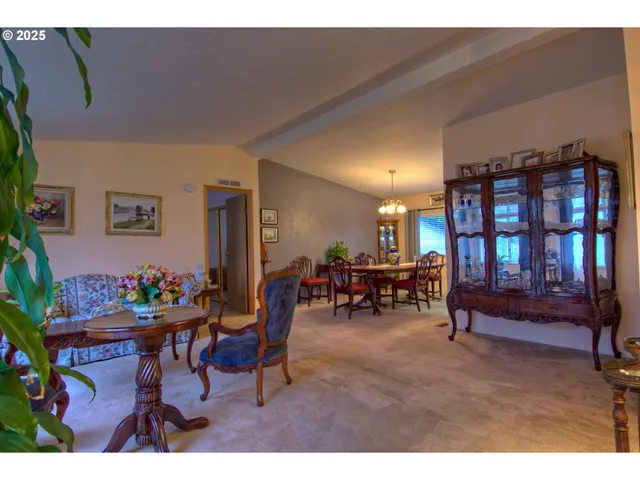 a living room with furniture and a dining table with bookshelf
