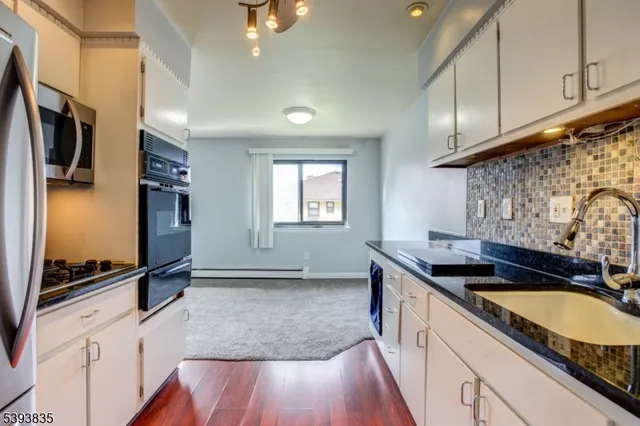 a kitchen with granite countertop a sink and a stove top oven