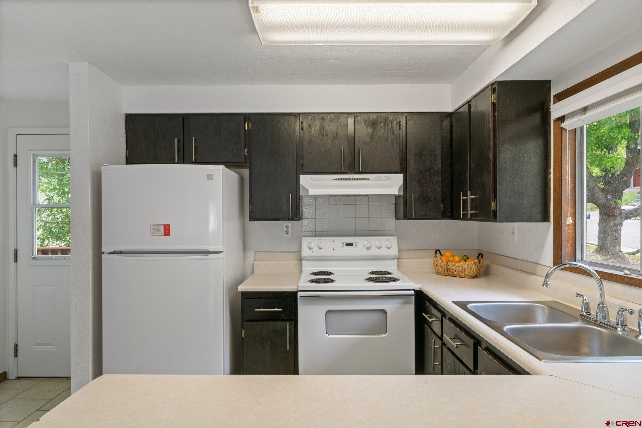 2913 Richard Drive Durango, CO 81301 - Photo 13 of 35 a kitchen with a refrigerator sink and white cabinets