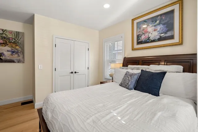 a bedroom with a bed and painting on the wall