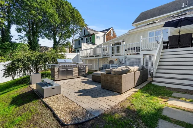 a view of a patio with couches table and chairs with plants and trees