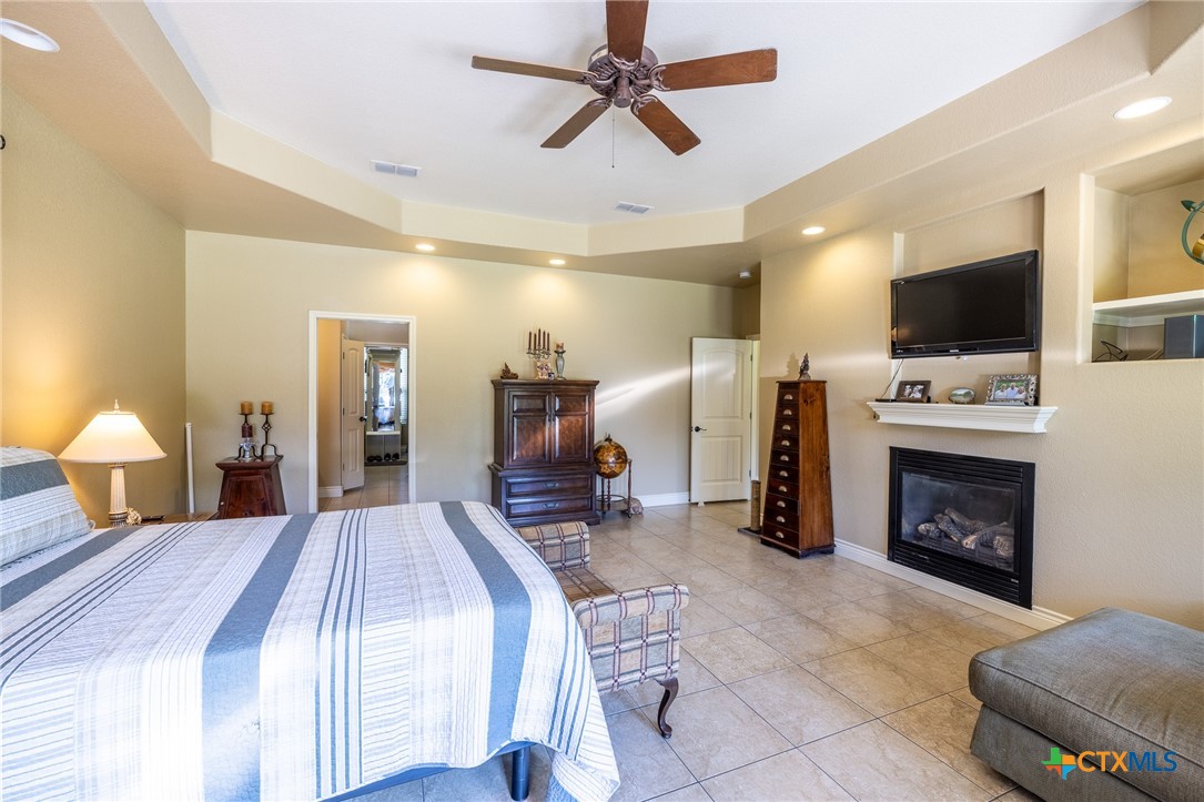 1338 Donovan Street Gonzales, TX 78629 - Photo 11 of 24 a spacious bedroom with a bed a flat screen tv and a chandelier