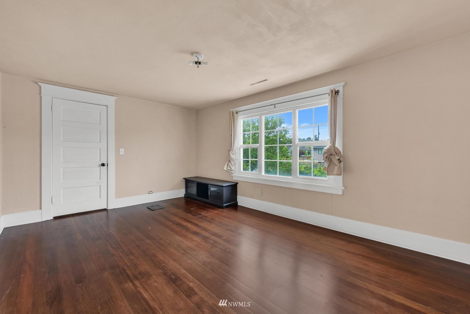 4852 South Orcas Street Seattle, WA 98118 - Photo 13 of 20 a view of an empty room with wooden floor and a window