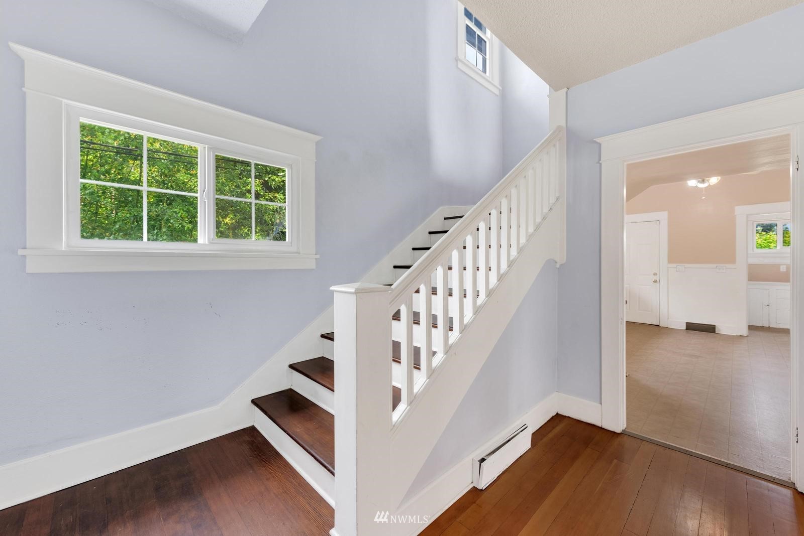 4852 South Orcas Street Seattle, WA 98118 - Photo 4 of 20 a view of entryway with wooden floor and stairs