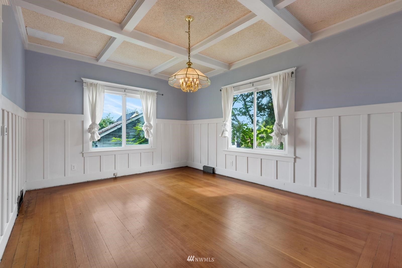 4852 South Orcas Street Seattle, WA 98118 - Photo 8 of 20 an empty room with wooden floor chandelier fan and windows