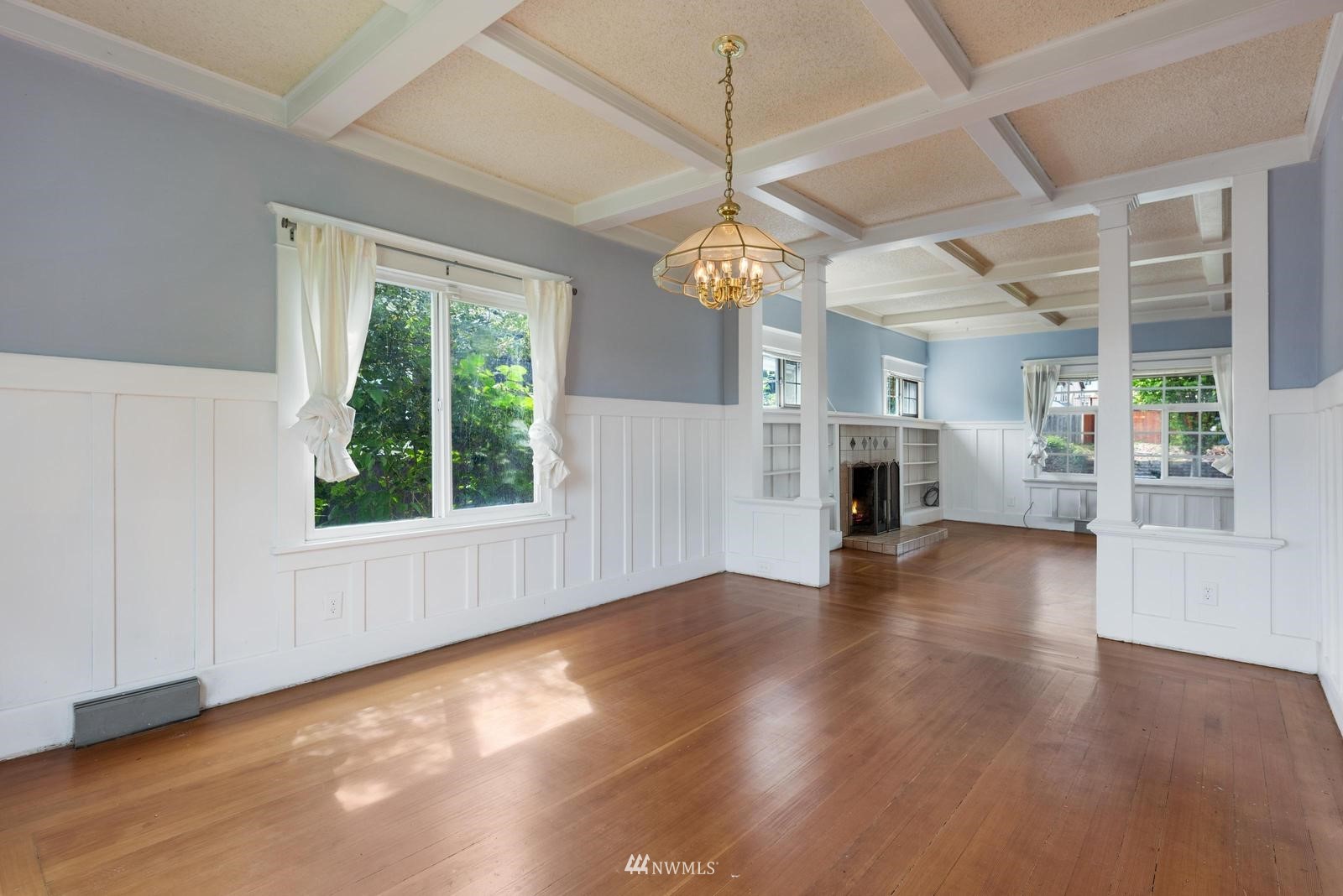 4852 South Orcas Street Seattle, WA 98118 - Photo 9 of 20 an empty room with wooden floor chandelier and windows