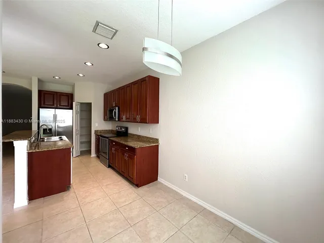 a kitchen with stainless steel appliances granite countertop a stove and a refrigerator