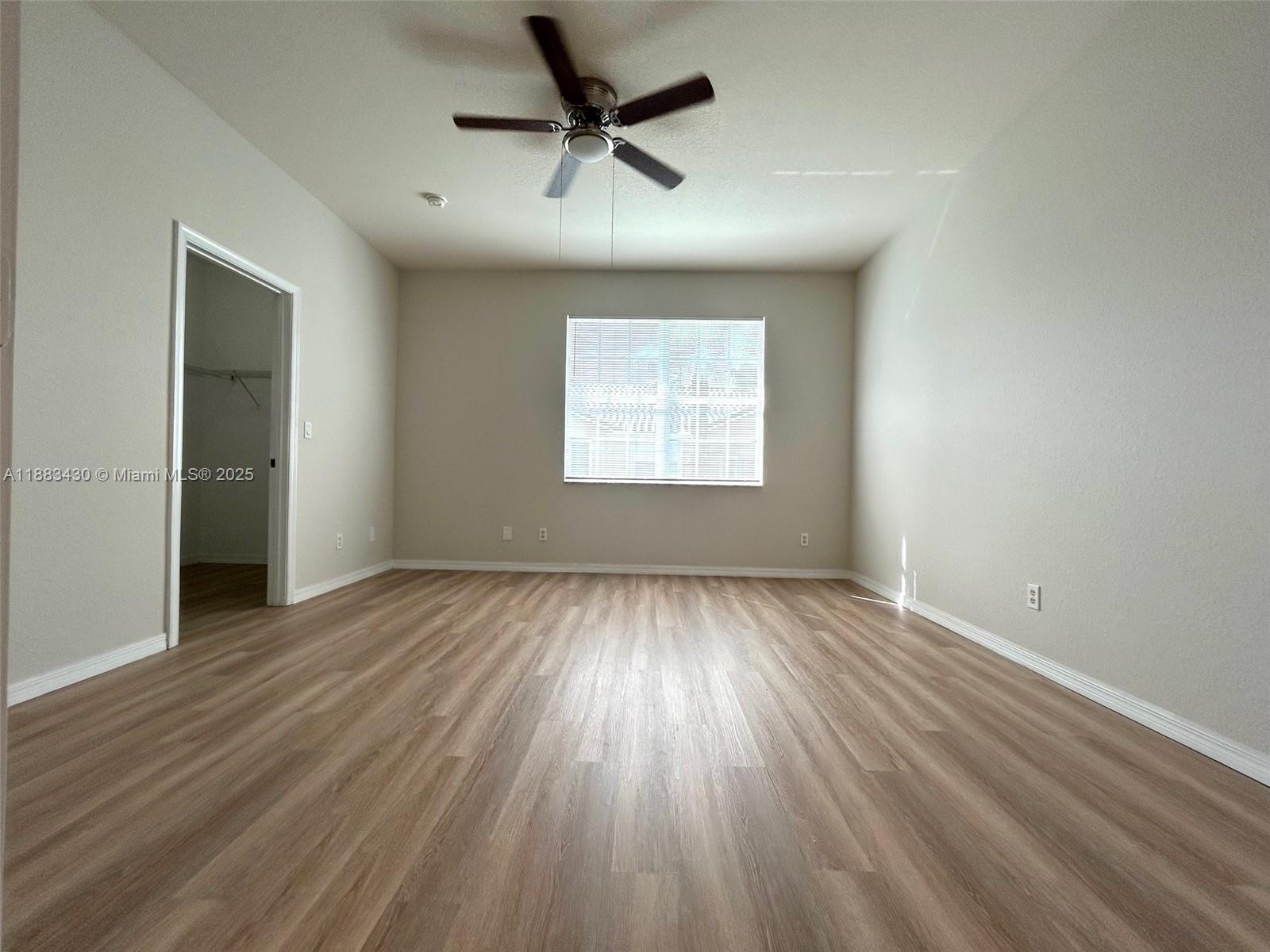 1560 Southeast Wilshire Place, Unit 103 Stuart, FL 34994 - Photo 17 of 33 wooden floor in an empty room with a window