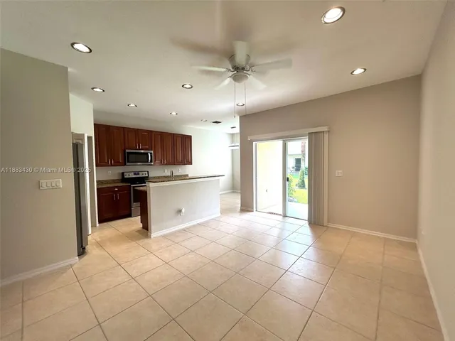 a large kitchen with stainless steel appliances granite countertop a refrigerator and a stove top oven