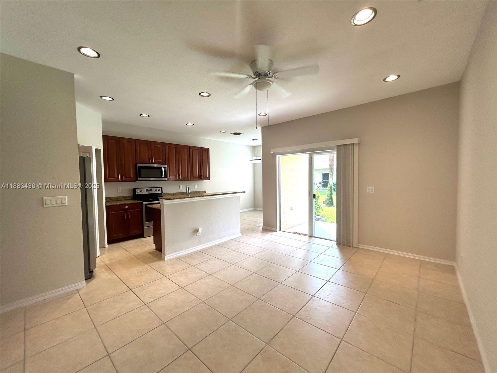 1560 Southeast Wilshire Place, Unit 103 Stuart, FL 34994 - Photo 5 of 33 a large kitchen with stainless steel appliances granite countertop a refrigerator and a stove top oven