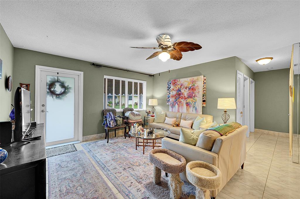4600 Northwest 45th Street Tamarac, FL 33319 - Photo 5 of 15 a living room with furniture a wooden floor and a flat screen tv