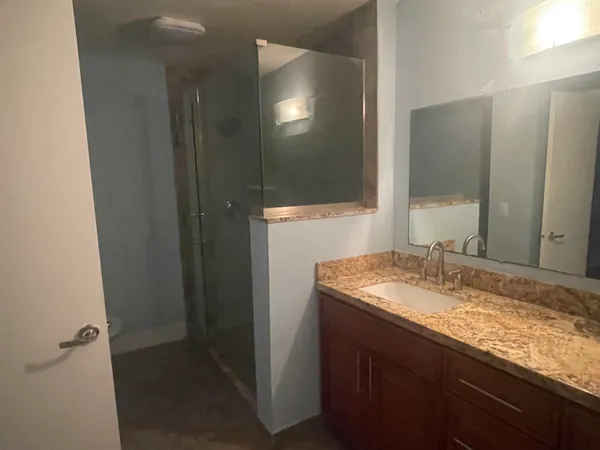 a bathroom with a granite countertop sink and a mirror