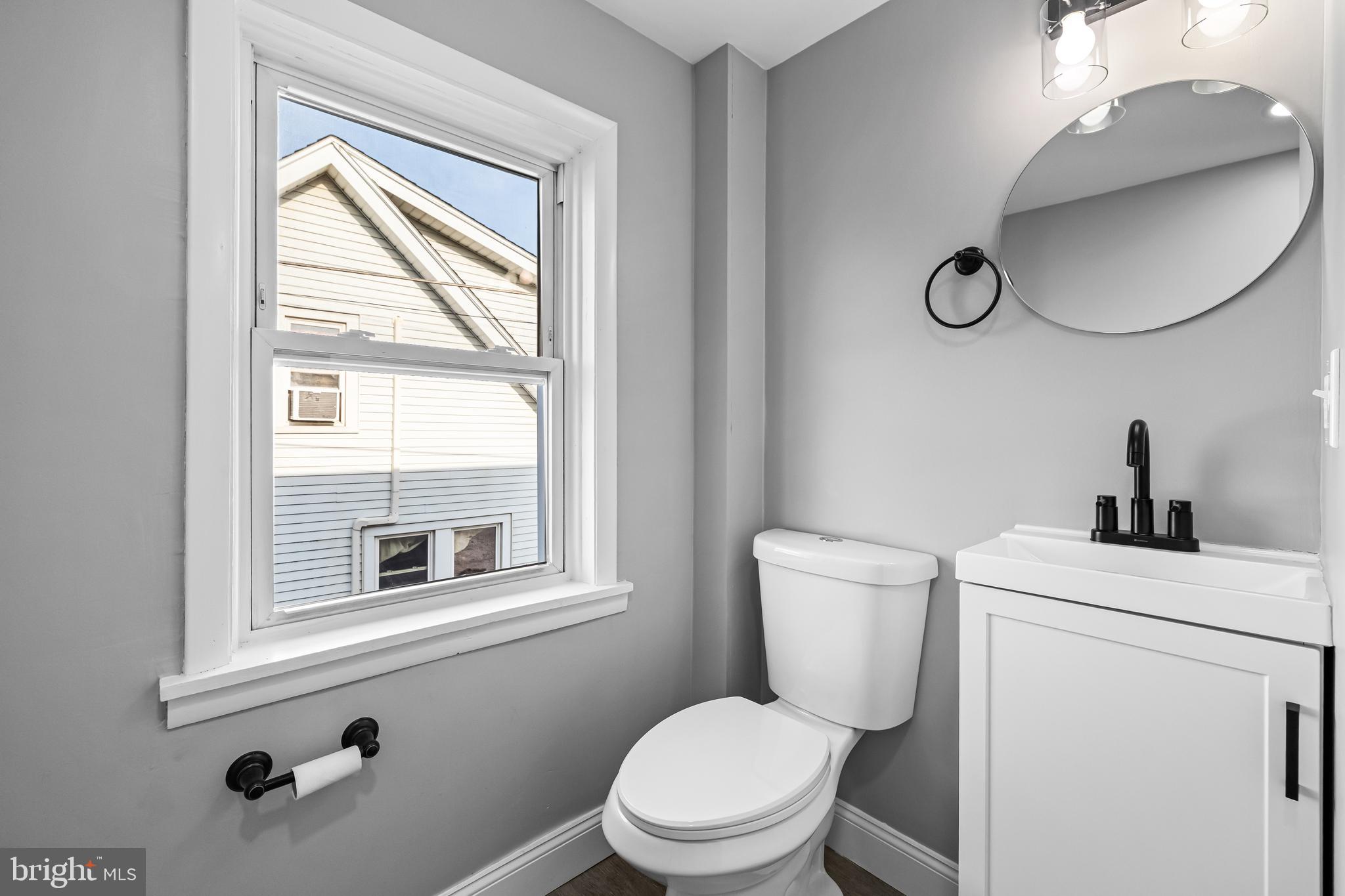 1480 Seven Valleys Road, Unit 2 York, PA 17408 - Photo 11 of 19 a bathroom with a toilet sink vanity and mirror