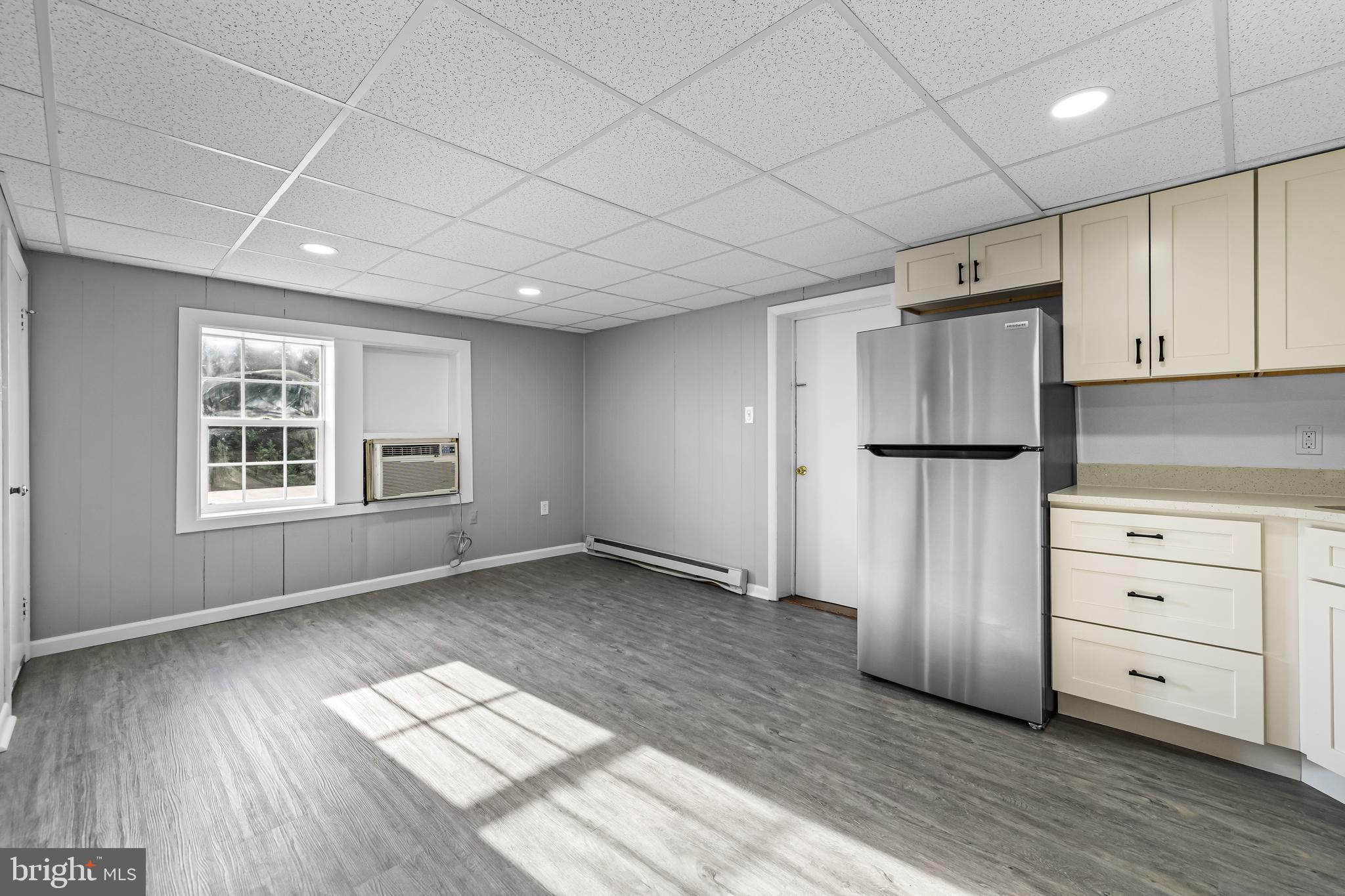 1480 Seven Valleys Road, Unit 2 York, PA 17408 - Photo 4 of 19 an empty room with wooden floor cabinet and windows