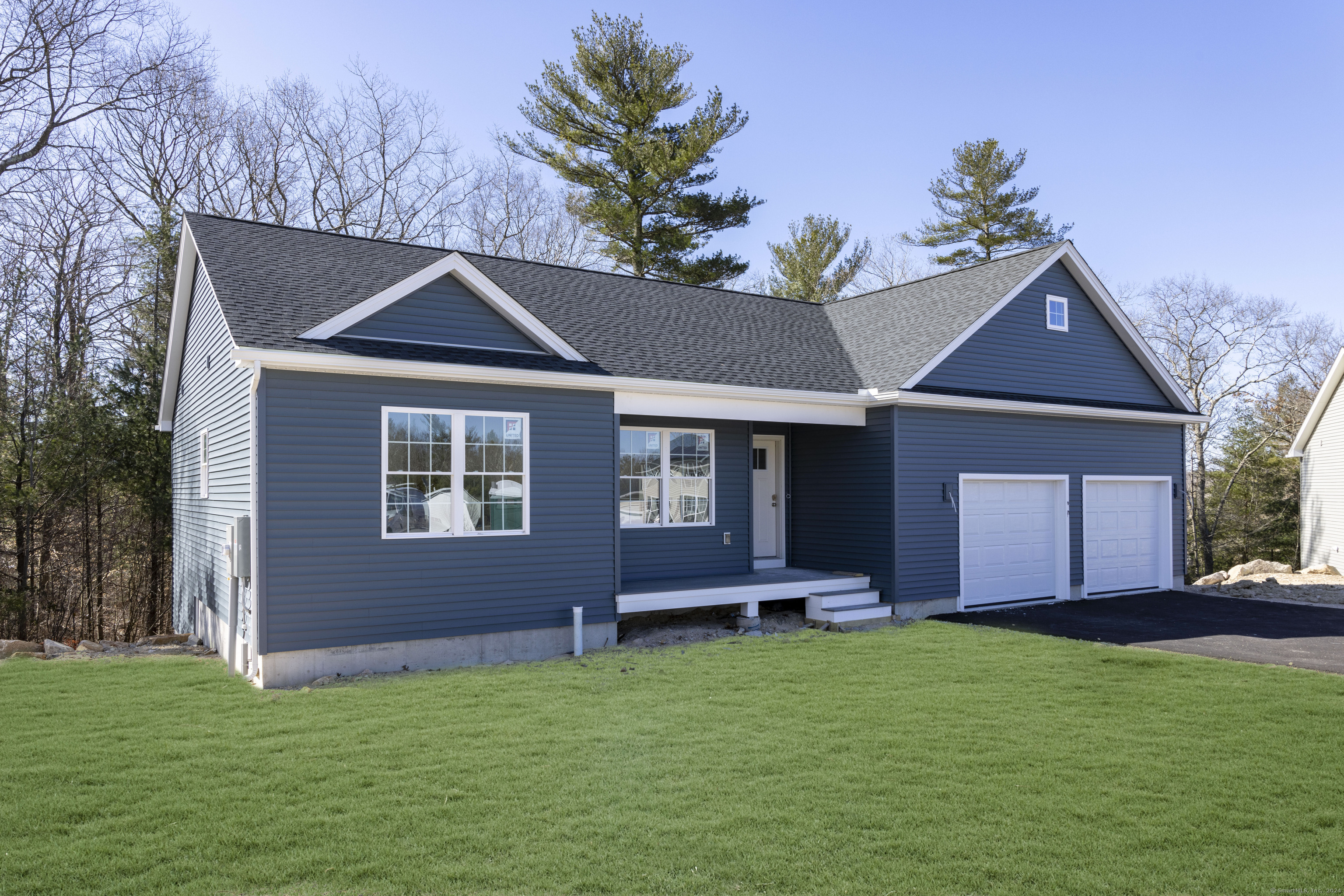 8 John's Circle Sterling, CT 06377 - Photo 19 of 29 a front view of a house with a garden and yard