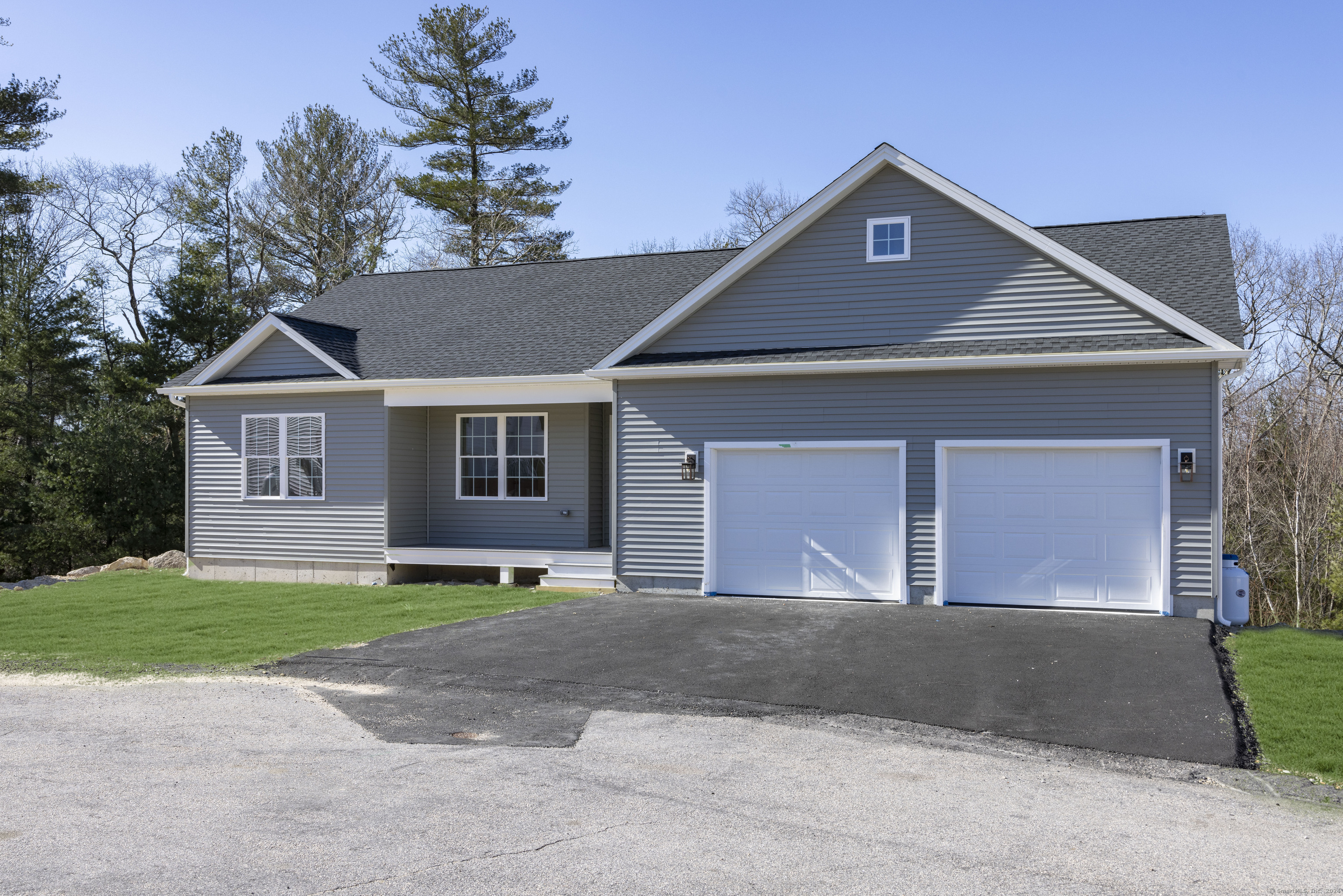 8 John's Circle Sterling, CT 06377 - Photo 22 of 29 a front view of a house with a garden and trees