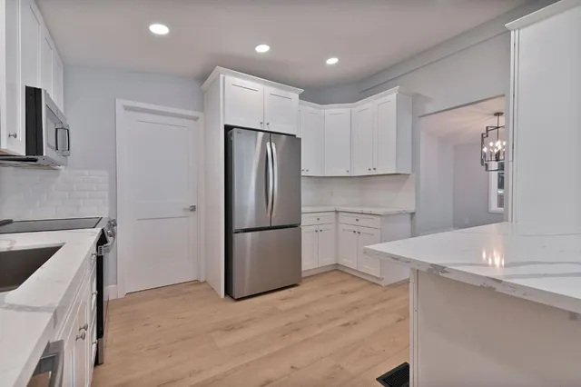 a kitchen with white cabinets and sink