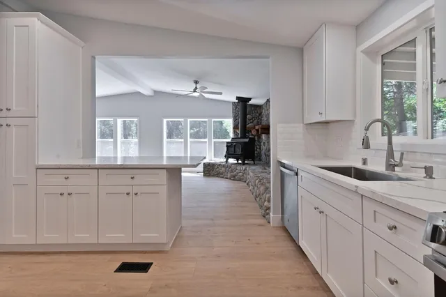 a kitchen with stainless steel appliances granite countertop a stove a sink and a microwave