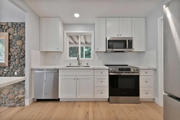 a view of empty room with window and refrigerator
