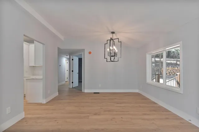 a view of empty room with window and refrigerator