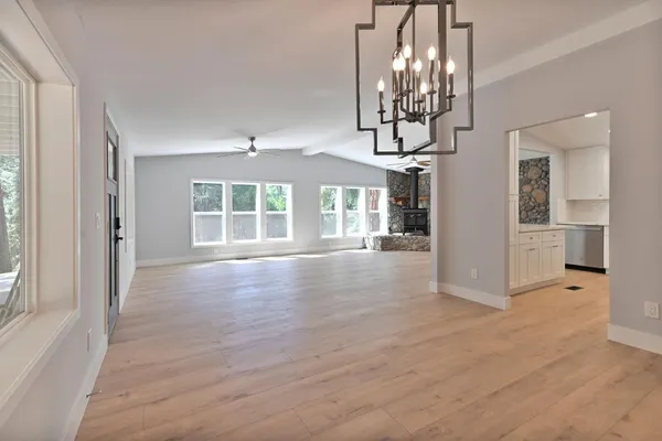 an empty room with a window and a fan