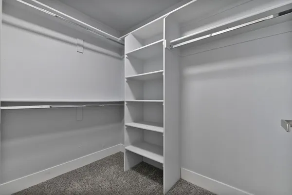 an empty room with closet and a chandelier fan