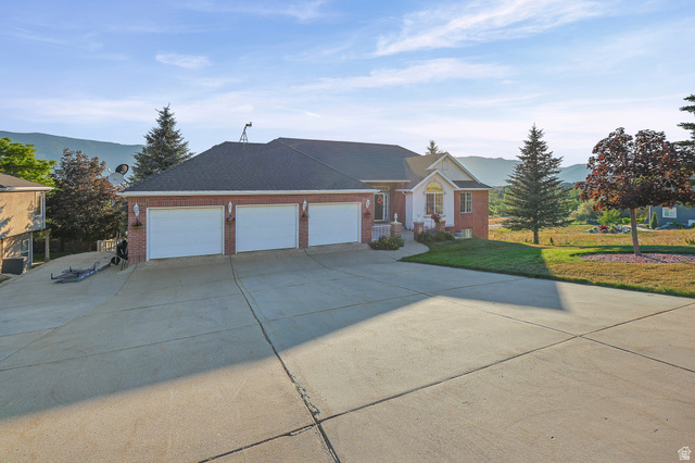 4117 North Wolf Ridge Circle Eden, UT 84310 - Photo 58 of 63 Brick exterior featuring a three-car garage and a concrete driveway