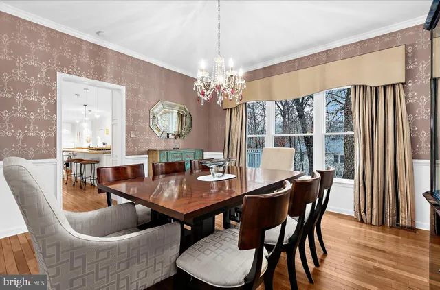 a dining room with stainless steel appliances granite countertop a kitchen island hardwood floor and a living room