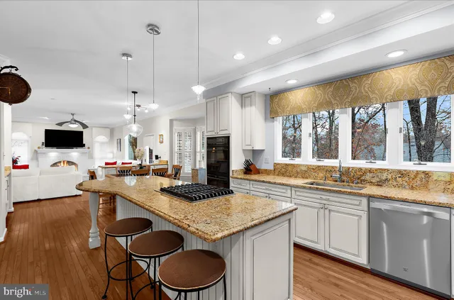 a kitchen with granite countertop white cabinets and a wooden floor