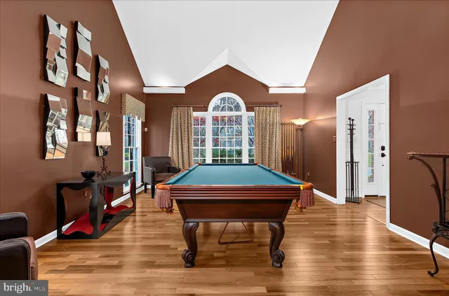 a kitchen with stainless steel appliances granite countertop a refrigerator a oven a stove and white cabinets with wooden floor