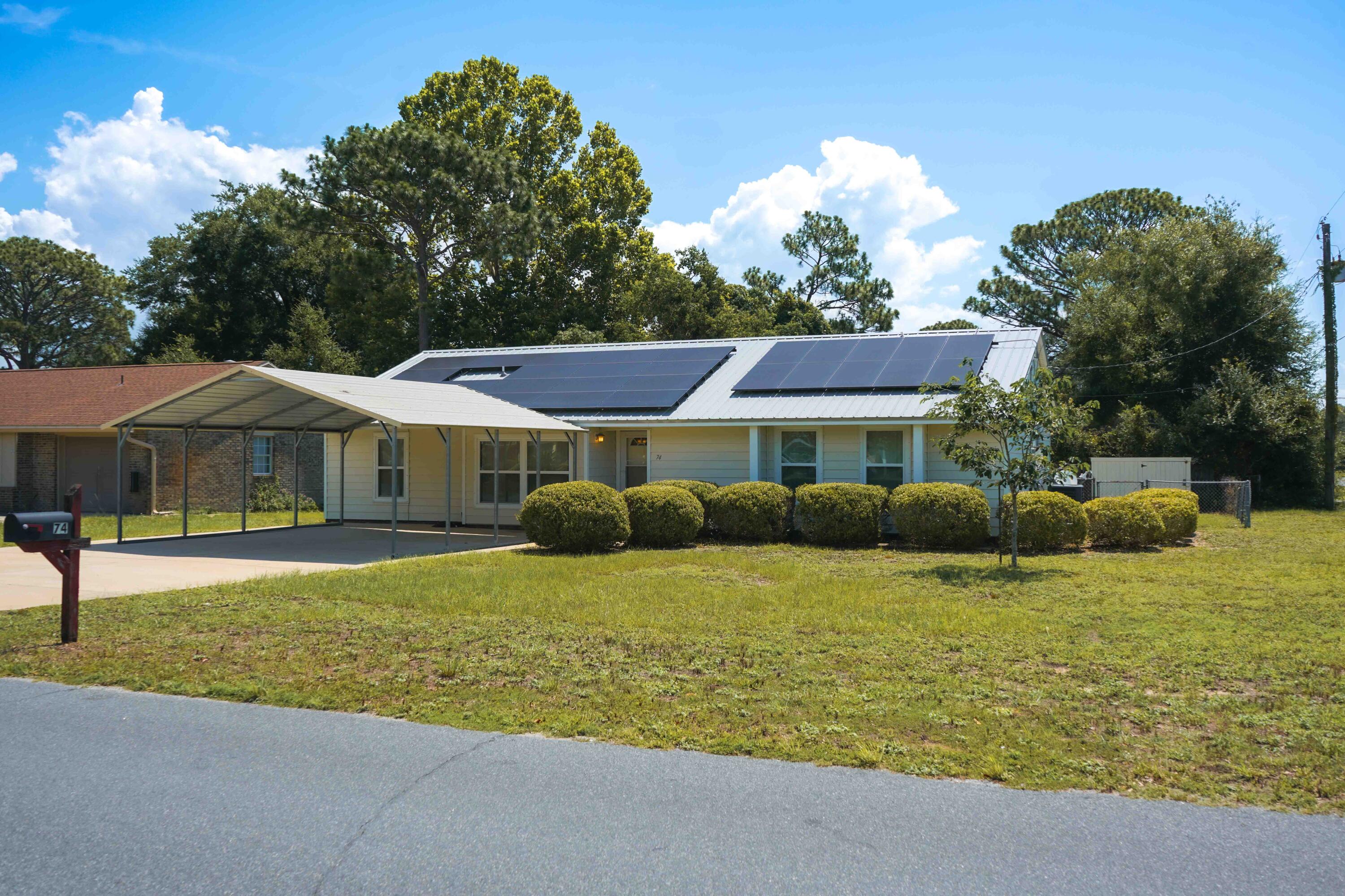 74 8th Street Shalimar, FL 32579 - Photo 1 of 26 a front view of a house with a garden