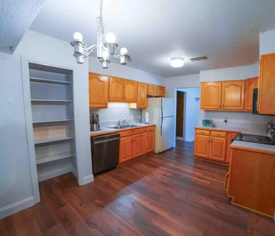 a kitchen with wooden floors and appliances