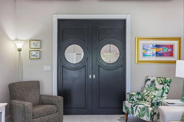 a spacious bedroom with a bed a table and large mirror