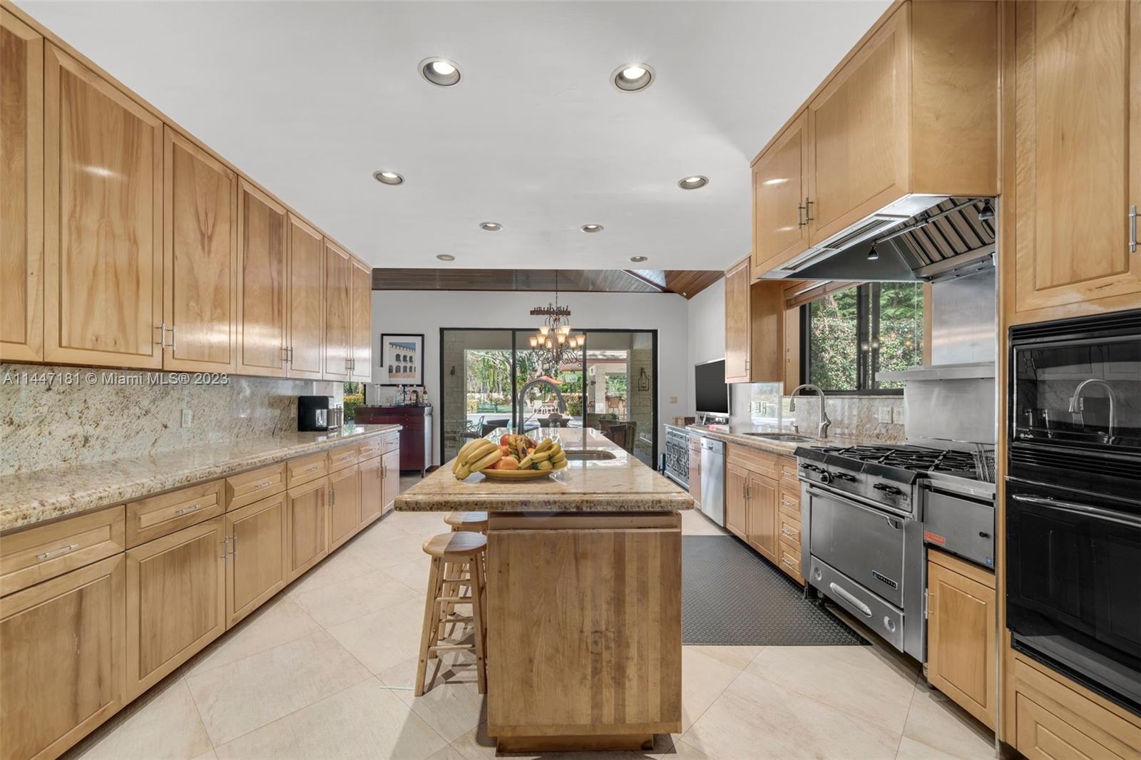 4875 Southwest 80th Street Miami, FL 33143 - Photo 13 of 52 a large kitchen with stainless steel appliances granite countertop a stove top oven a sink dishwasher and cabinets with wooden floor