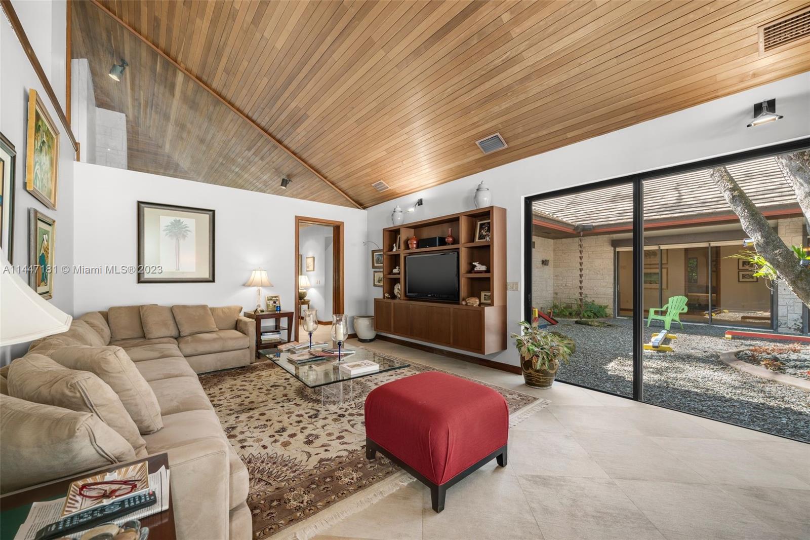 4875 Southwest 80th Street Miami, FL 33143 - Photo 17 of 52 a living room with furniture a flat screen tv and floor to ceiling window