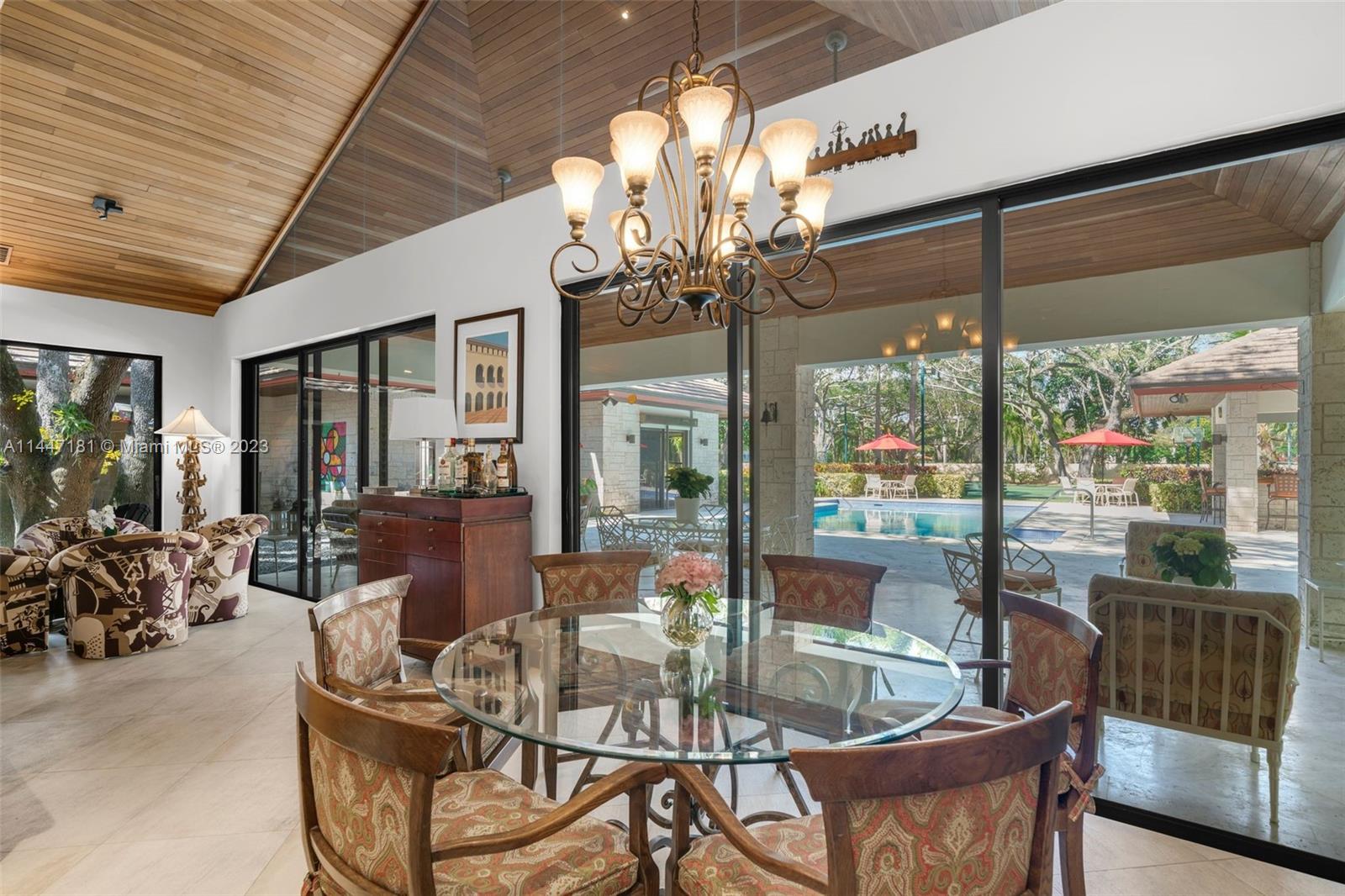 4875 Southwest 80th Street Miami, FL 33143 - Photo 19 of 52 a view of a dining room with furniture large windows and wooden floor