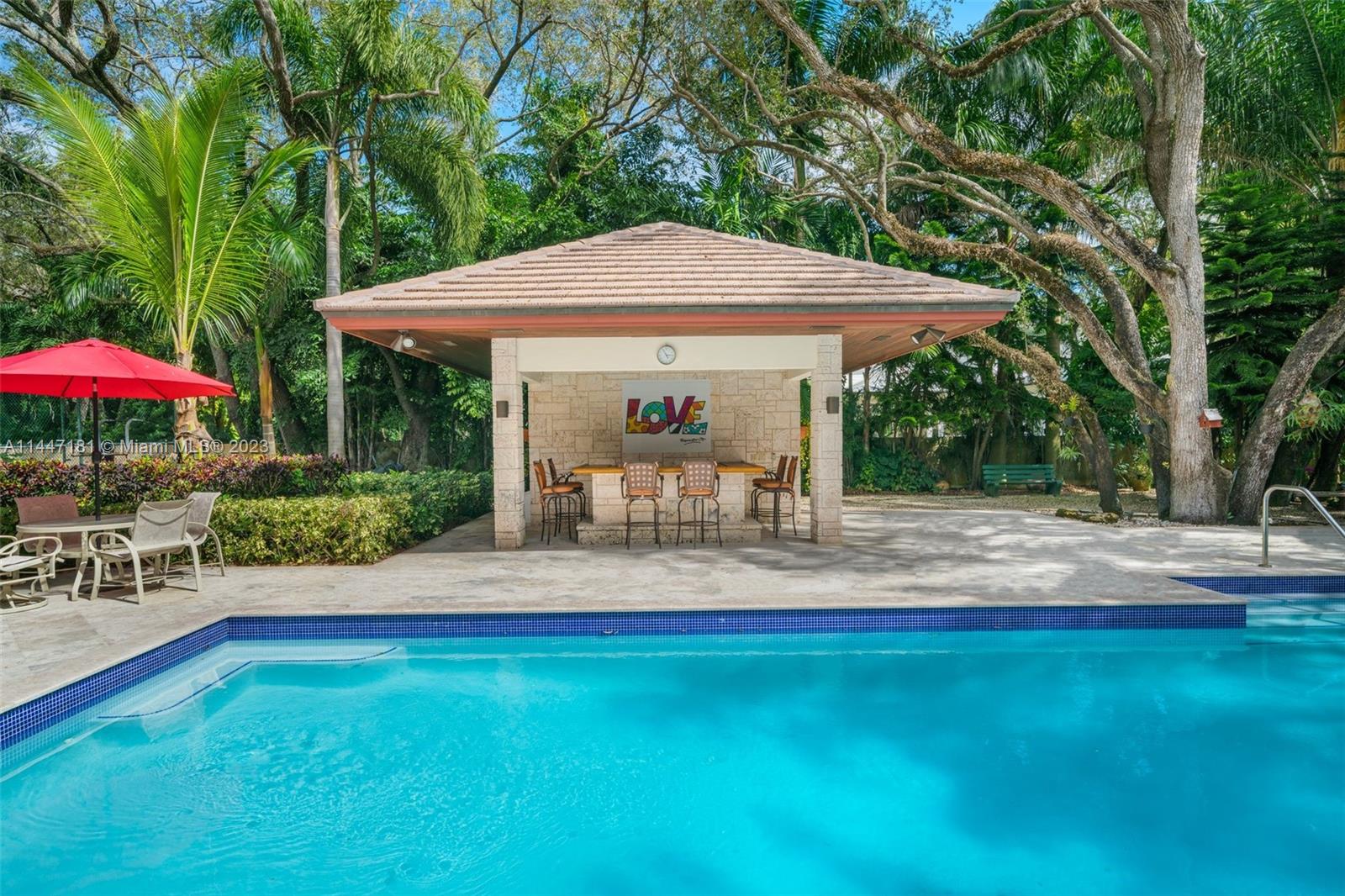 4875 Southwest 80th Street Miami, FL 33143 - Photo 39 of 52 a view of a patio with table and chairs under an umbrella