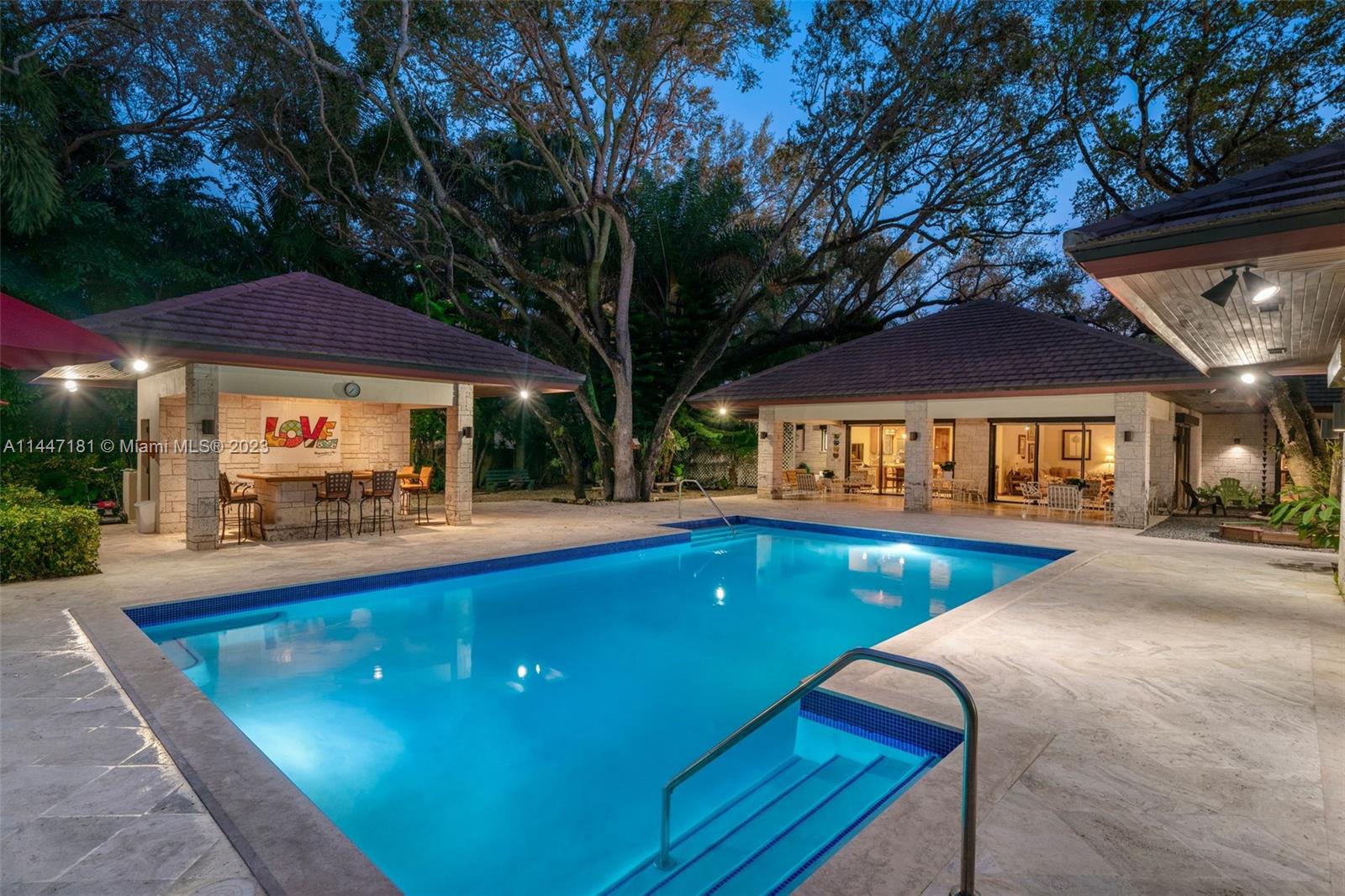 4875 Southwest 80th Street Miami, FL 33143 - Photo 48 of 52 a view of swimming pool with chairs and table under an umbrella