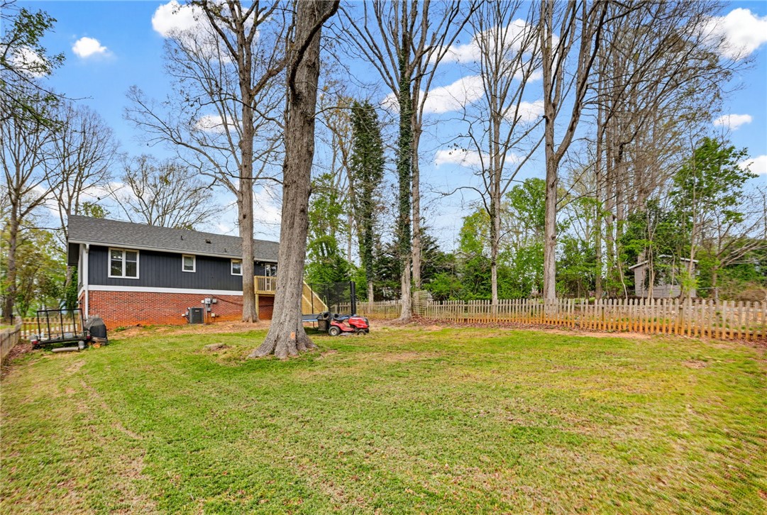 137 Towne Creek Trail Anderson, SC 29621 - Photo 21 of 23 This spacious yard offers ample green space, mature trees, and a classic picket fence.