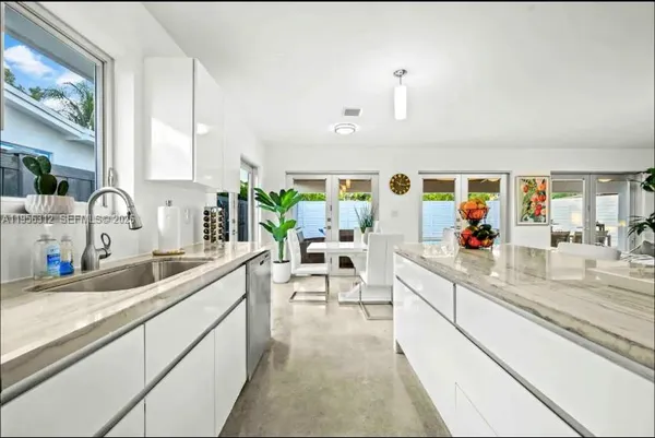 a view of a refrigerator in kitchen and white cabinets