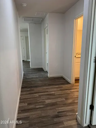 a view of a hallway with wooden floor and staircase