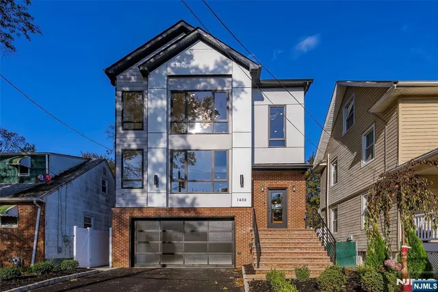 a front view of a house with glass windows and entryway