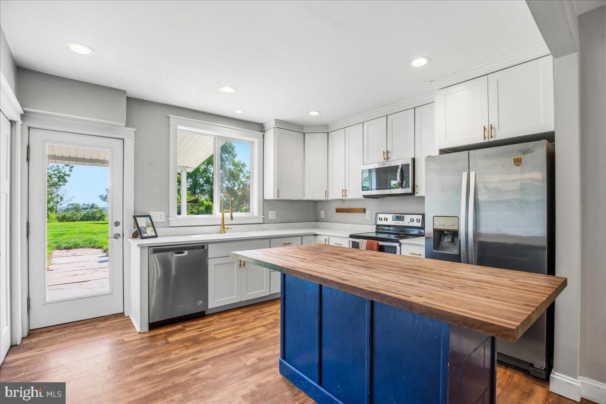 16146 Thomas Road Piney Point, MD 20674 - Photo 13 of 70 a kitchen with stainless steel appliances granite countertop a refrigerator a sink dishwasher a stove and white countertops with wooden floor