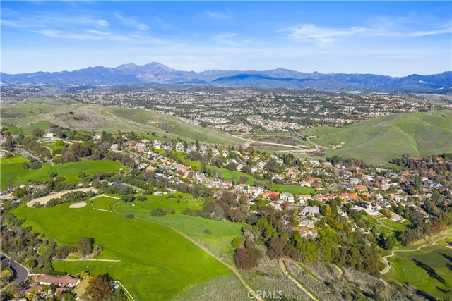 an aerial view of residential houses with outdoor space and trees