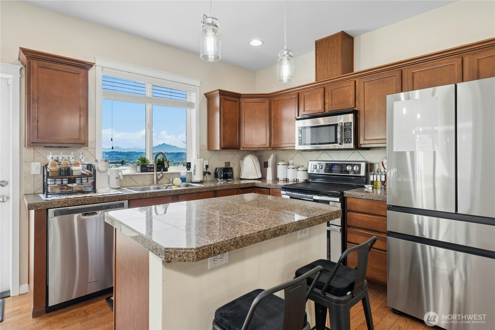527 Pilchuck Path Everett, WA 98201 - Photo 11 of 38 a kitchen with stainless steel appliances granite countertop a sink refrigerator and microwave