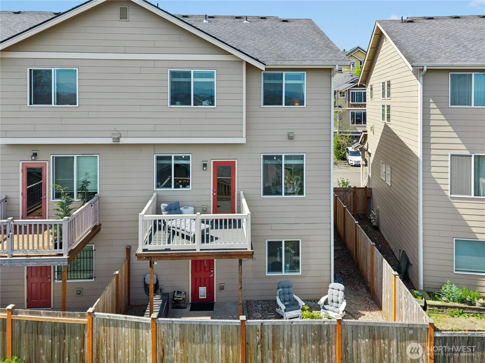 527 Pilchuck Path Everett, WA 98201 - Photo 34 of 38 a view of a white house with large windows and wooden fence
