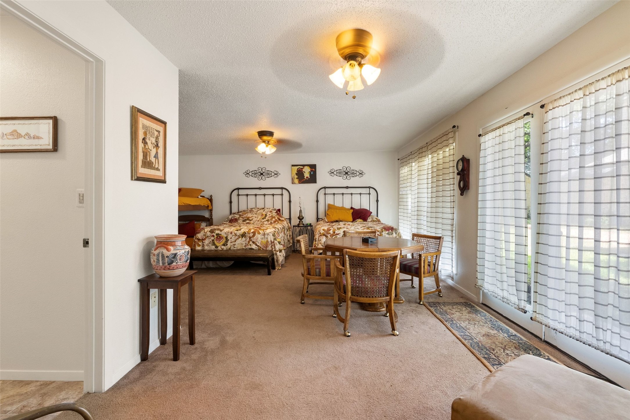 141 Perry Lane Kingsland, TX 78639 - Photo 35 of 40 A well-lit guest room features ample space for multiple beds and a charming seating area.
